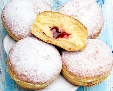 Traditional Polish donuts on wooden powder. Tasty doughnuts with jam.